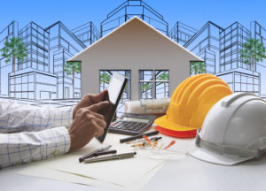 hand of architect working on computer tablet with construction industry and engineer working tool on top of table against home out line and sketching of modern building perspective